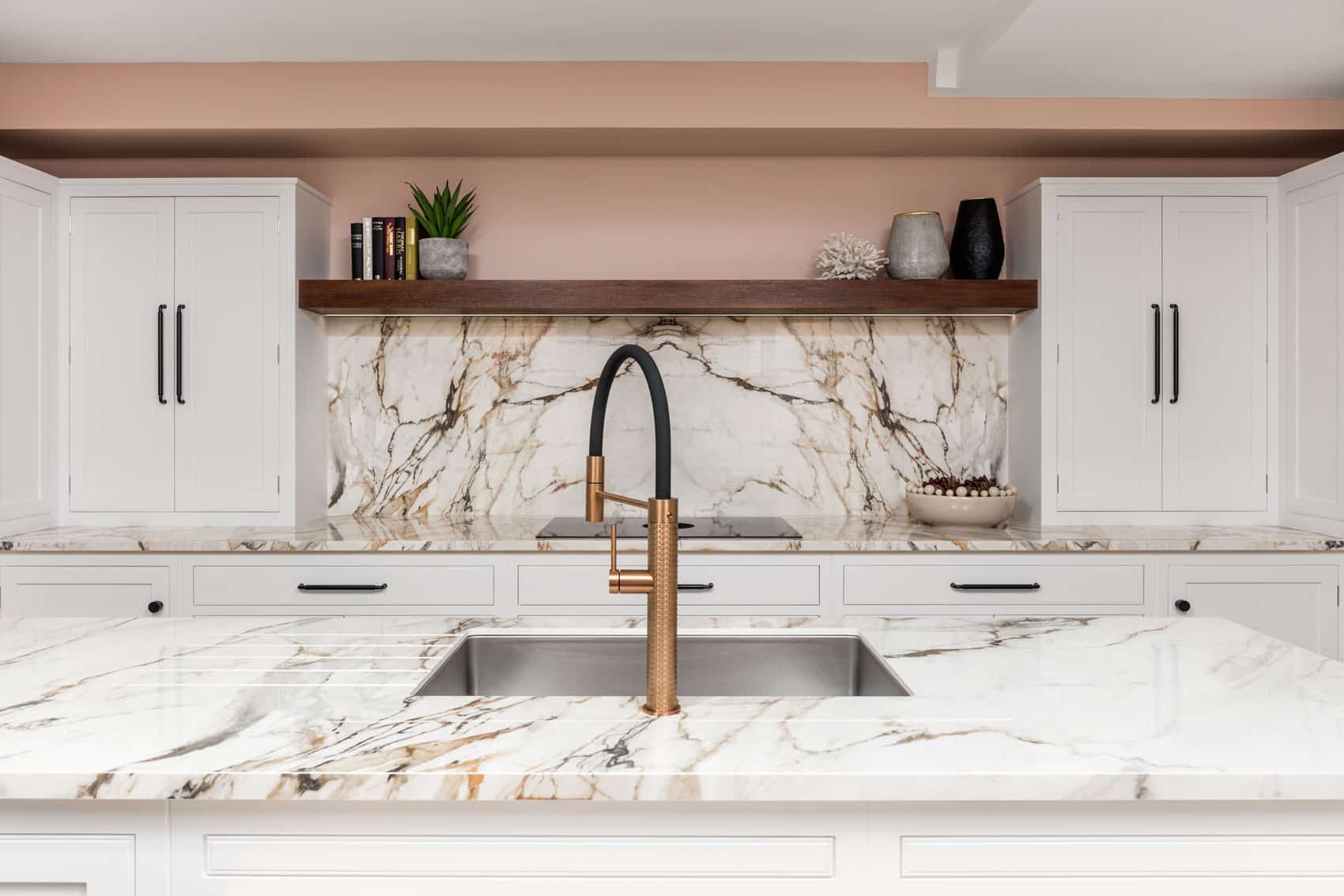 White Arbor kitchen cabinetry with white and pink marble worktops against pale pink walls