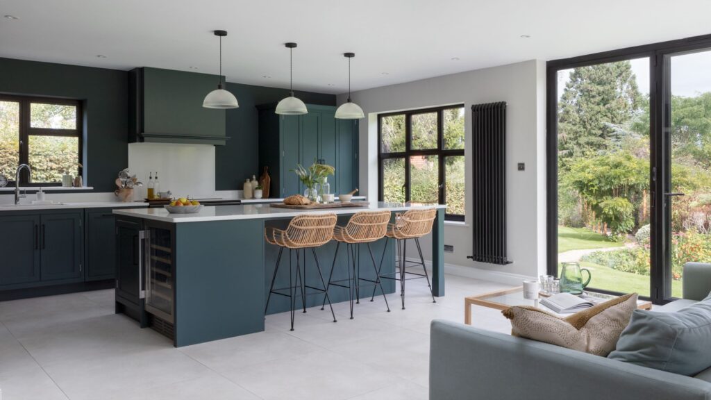 Teal kitchen cabinetry and kitchen island with white worktops